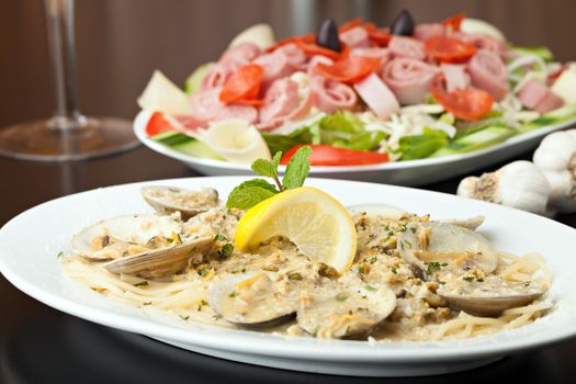 Italian pasta dish with fresh clams over pasta with herbs and cheese.  Shallow depth of field.