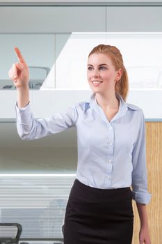 Young beautiful businesswoman pointing at copyspace