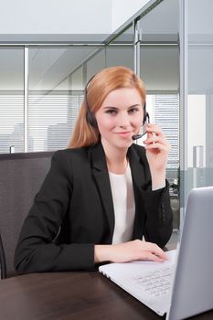 Businesswoman sit at desk and talking on headset 