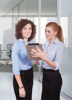 two woman using tablet in office