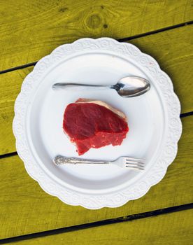 Damp meat on plate on white background