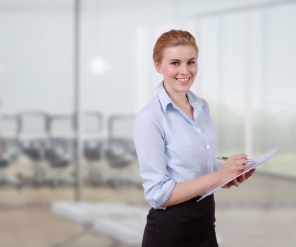Young Businesswoman with Folio in her office