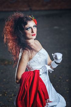 Attractive bride in a wedding dress with bright makeup, red shawl