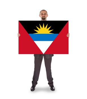 Smiling businessman holding a big card, flag of Antigua and Barbuda