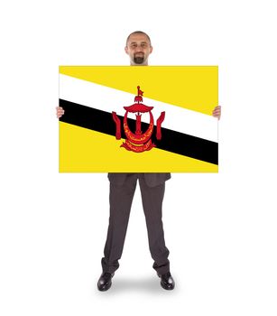 Smiling businessman holding a big card, flag of Brunei