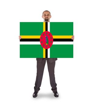 Smiling businessman holding a big card, flag of Dominica