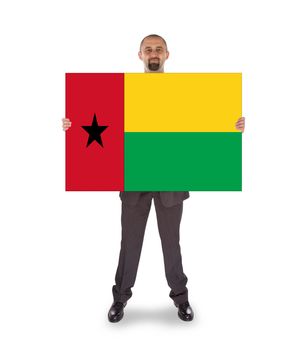 Smiling businessman holding a big card, flag of Guinea-Bissau