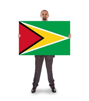 Smiling businessman holding a big card, flag of Guyana
