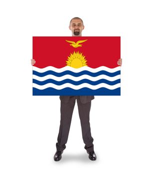 Smiling businessman holding a big card, flag of Kiribati