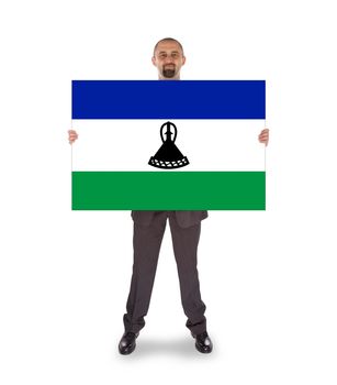 Smiling businessman holding a big card, flag of Lesotho