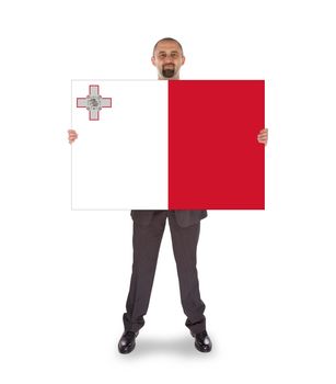 Smiling businessman holding a big card, flag of Malta