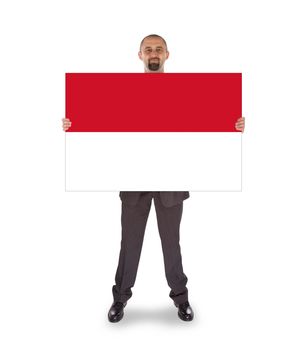 Smiling businessman holding a big card, flag of Monaco