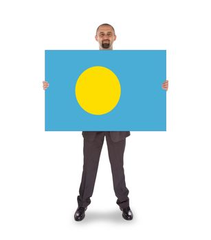 Smiling businessman holding a big card, flag of Palau