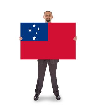Smiling businessman holding a big card, flag of Samoa