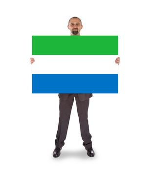 Smiling businessman holding a big card, flag of Sierra Leone