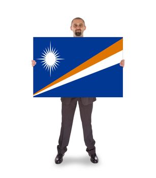 Smiling businessman holding a big card, flag of The Marshall Islands