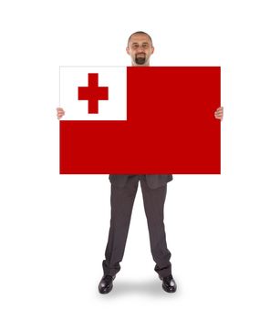 Smiling businessman holding a big card, flag of Tonga