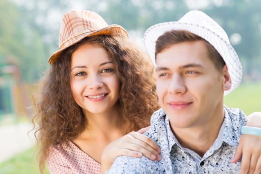 romantic couple lying on the grass in the summer park, spending time with loved ones