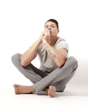 Man sitting and pointing a finger on his mouth