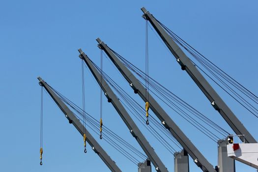 Four large cranes on board a cargo ship