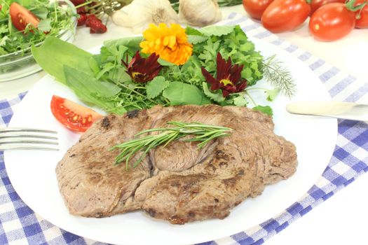 Sirloin steak with wild herb salad on a light background