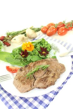 fresh Sirloin steak with wild herb salad on a light background