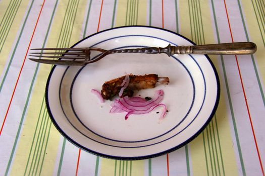 fork with knife on dish with  meat and onions