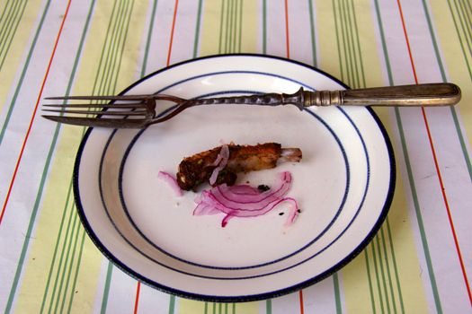 fork with knife on dish with  meat and onions