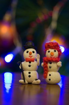 Two snowmen decoration by the Christmas tree 