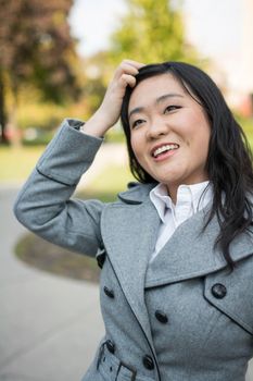 Young Asian woman laughing at the end of a road