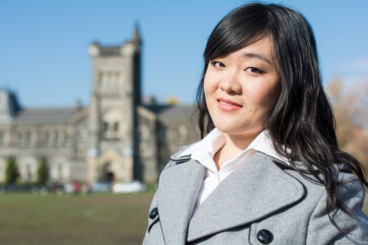 Outdoor portrait of young woman with old structure in the background