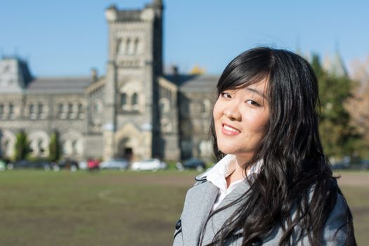 Outdoor portrait of young woman with old structure in the background