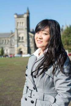 Outdoor portrait of young woman with old structure in the background