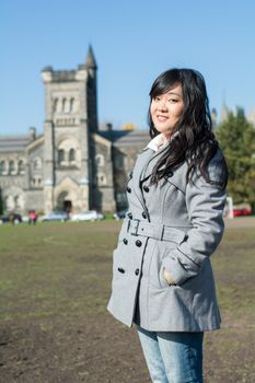 Outdoor portrait of young woman with old structure in the background