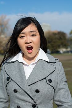 Outdoor portrait of young woman looking surprised