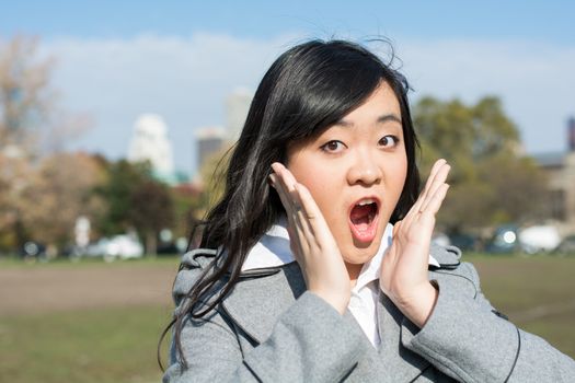 Outdoor portrait of young woman looking surprised