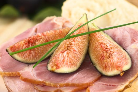 Fresh fig slices on smoked ham sandwich garnished with chives (Selective Focus, Focus on the middle of the image)