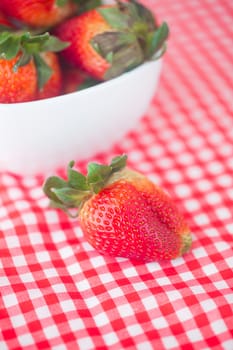 strawberries in bowl on checkered fabric