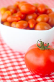 cherry tomatos and tomatos in bowl on checkered fabric