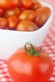 cherry tomatos and tomatos in bowl on checkered fabric