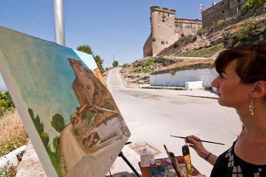 Painter paint a castle of Sabiote, Jaen province, Andalusia, Spain