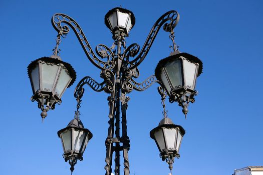 A wrought iron lamp on a weathered wall in Spain