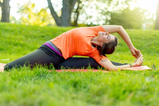 Portrait of a girl meditation and taking yoga poses at sunset under trees