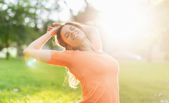 Beauty portrait of an attractive multi-ethnic girl enjoying the warmth of a summer sunset. Sun Flare serie