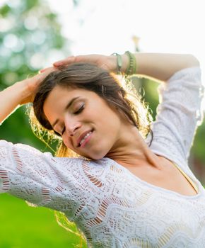 Beauty portrait of an attractive multi-ethnic girl enjoying the warmth of a summer sunset. Sun Flare serie