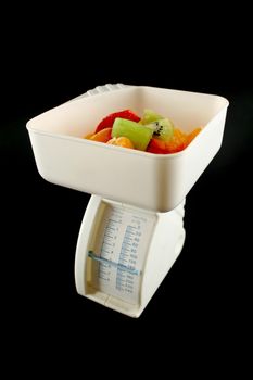 Set of kitchen scales weighing fresh fruit.