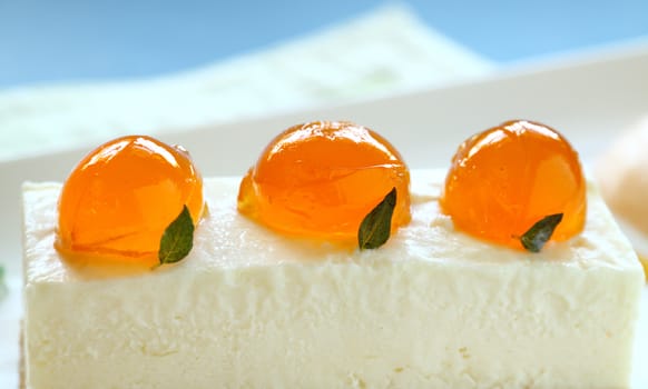 Delicious mandarin cheese cake with mandarin jelly balls and a fruit sauce.
