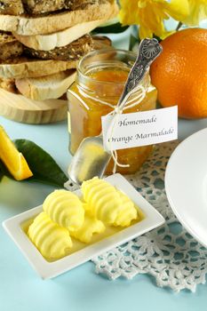 Homemade orange marmalade with toast and butter ready to serve.