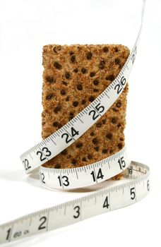 Low calorie rye cracker wrapped in a tape measure.