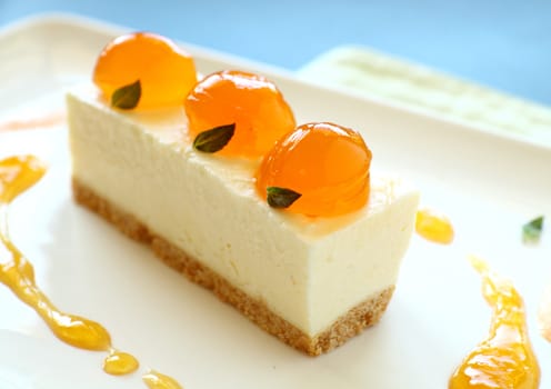 Delicious mandarin cheese cake with mandarin balls and a fruit sauce.